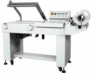 Industrial L1911 shrink wrap machine with control panel and film roll, isolated on a white background.